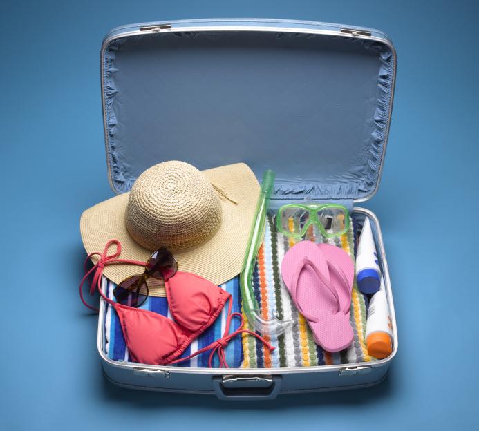 Suitcase packed with beachwear.