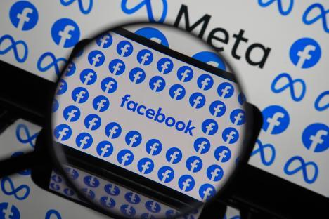 Photo illustration of Facebook logos on a phone screen viewed through a magnifying glass.