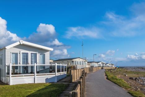 Row of caravans at a sunny seaside park.