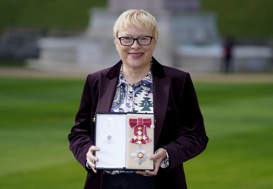 Dame Angela Eagle holding her Damehood medal and star.
