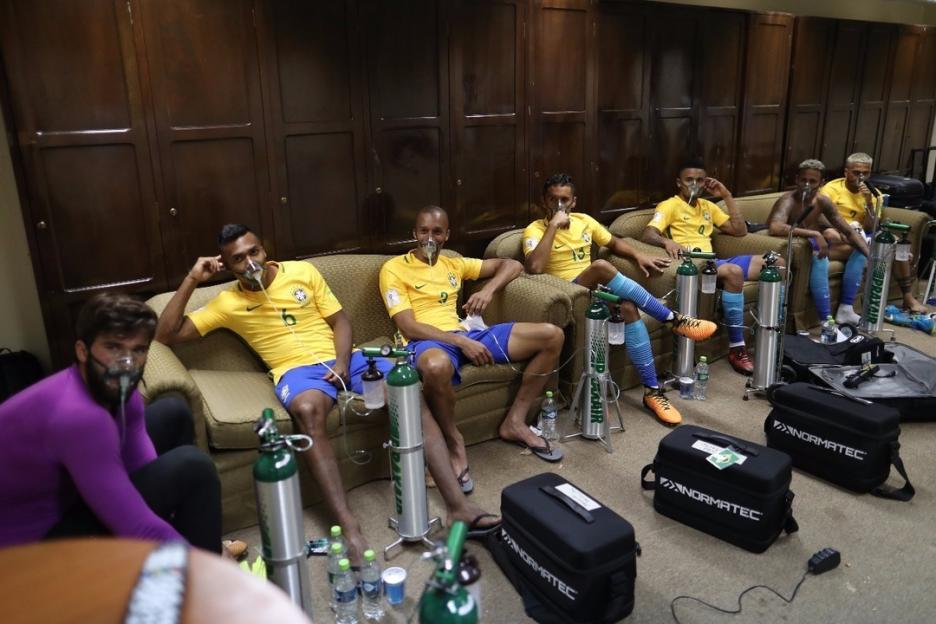 Brazilian soccer players using oxygen tanks in a dressing room after a game.