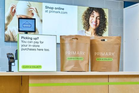 Primark click and collect counter with payment terminal and bags.