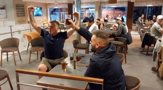 Two men celebrating at a bar.