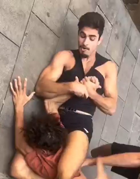 Two people performing a maneuver on the ground.
