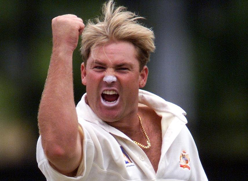 Australian leg-spinner Shane Warne celebrates a wicket with a fist pump and white zinc cream on his nose and mouth.