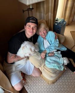 Brooklyn Beckham with his grandmother and two small white dogs.