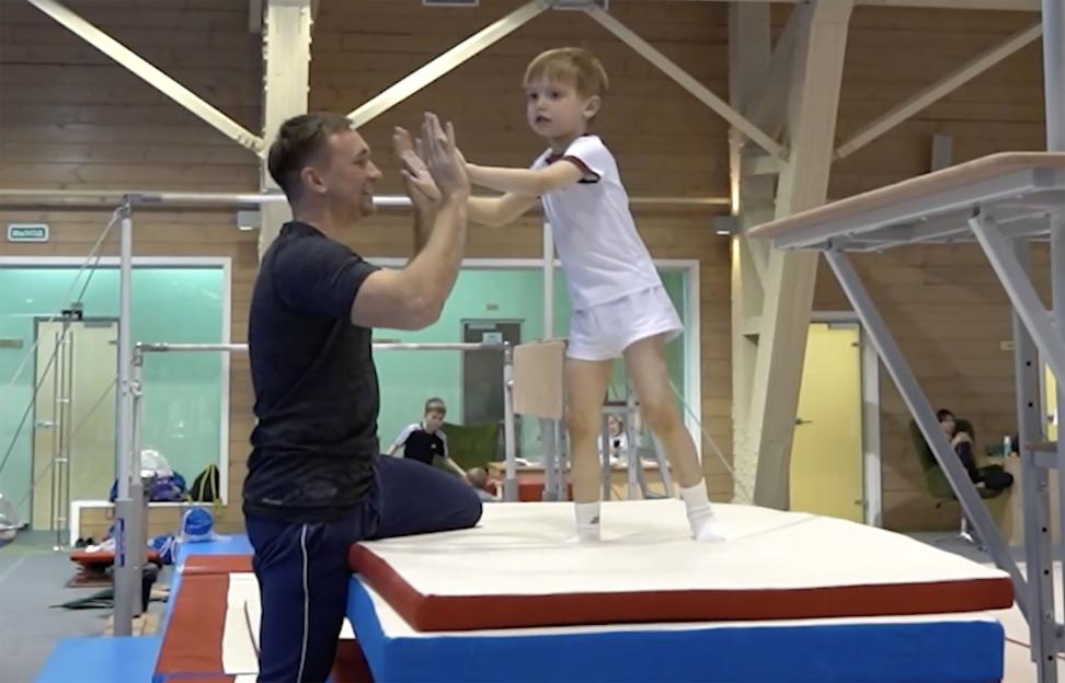 Vladimir Putin's six-year-old son high-fiving his gymnastics coach.