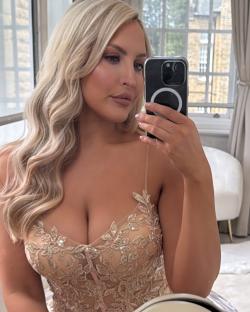Woman taking a selfie in a beige lace dress.