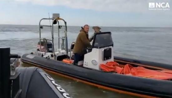 Two men on a rigid-hulled inflatable boat after a cocaine seizure.