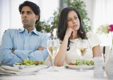 Unhappy mixed-race couple dining together.