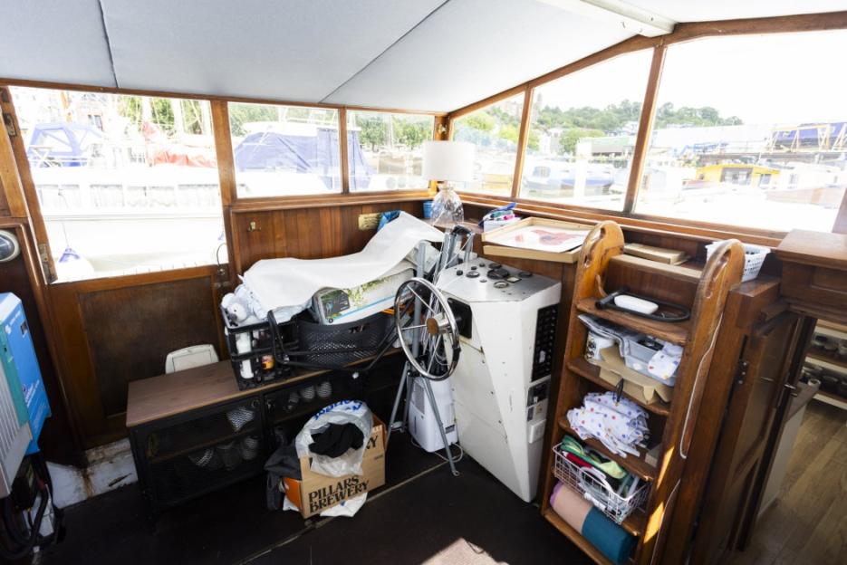 Interior of a houseboat cluttered with boxes and belongings.