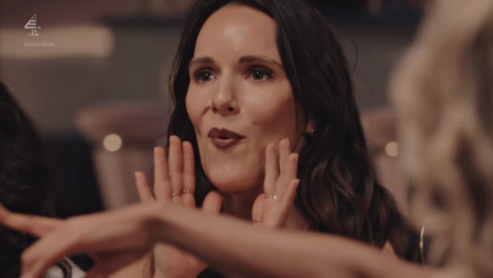 A woman expressing excitement, with her hands near her face.
