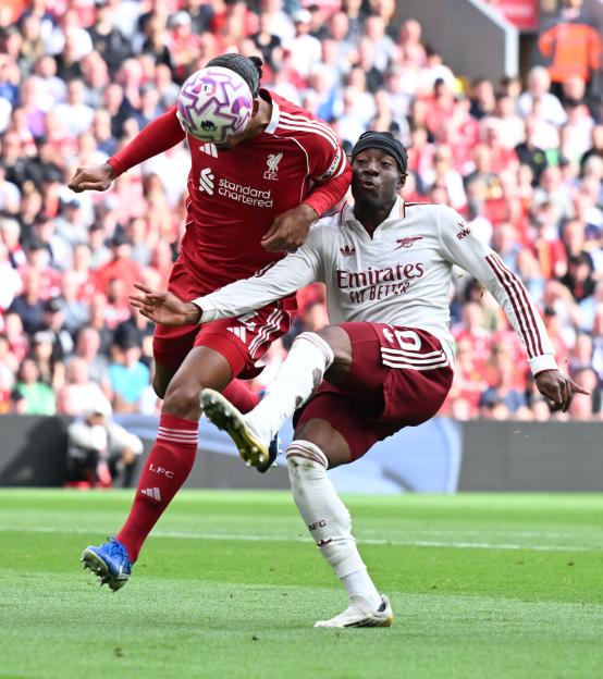 Noni Madueke of Arsenal challenged by Virgil van Dijk of Liverpool during a Premier League match.
