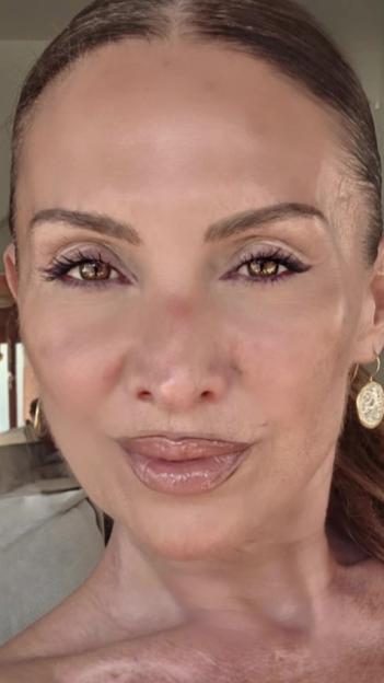 Close-up of a woman's face with brown eyes and glossy lips.