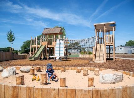 Toddler playing in a sandpit at Mill Rythe Holiday Park playground.