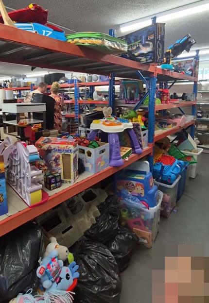 A thrift store with shelves full of toys.