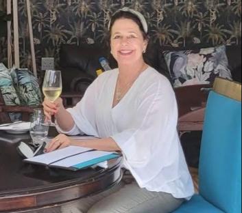 Karen Carter holding a glass of wine at a table.