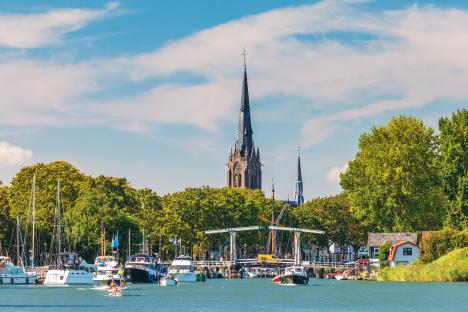 Boats on the river Vecht in Weesp, Netherlands, with church spires in the background.