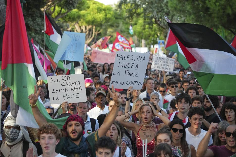 Protestors at a march in Venice hold signs advocating for peace and Palestinian liberation.
