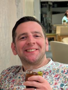 Man smiling and holding a drink.