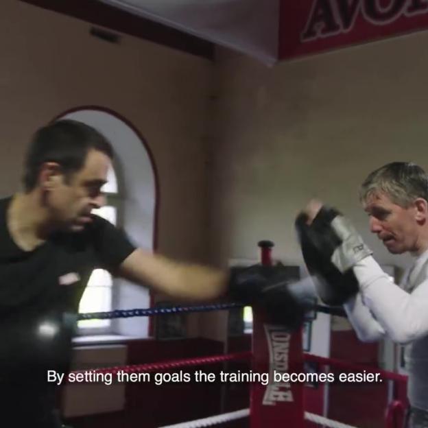 Ronnie O'Sullivan boxing a punch bag.