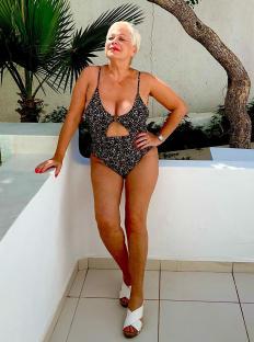 Woman in floral swimsuit and white sandals.