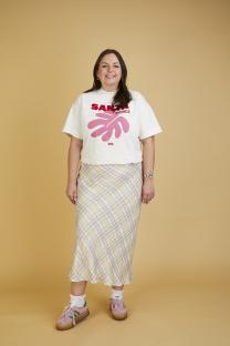 Woman wearing a Santa Monica t-shirt and plaid skirt.