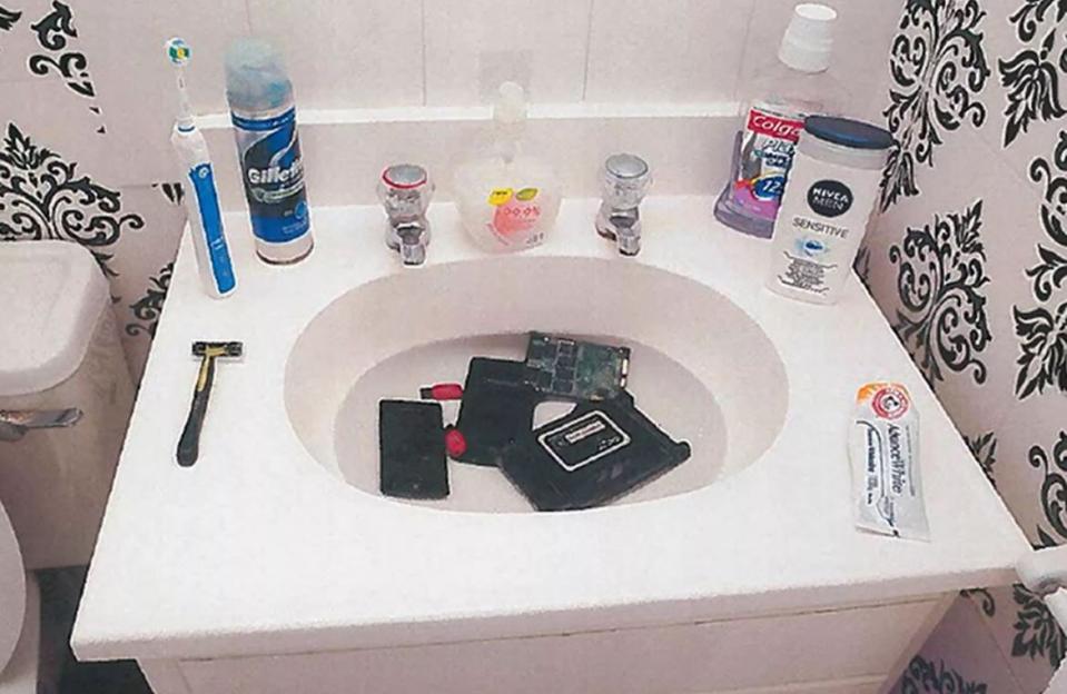 Electronics submerged in a bathroom sink.