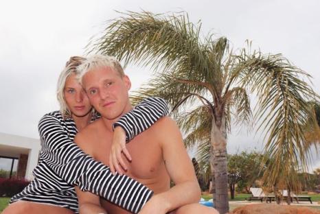 Frankie Gaff and Jamie Laing embracing under a palm tree.