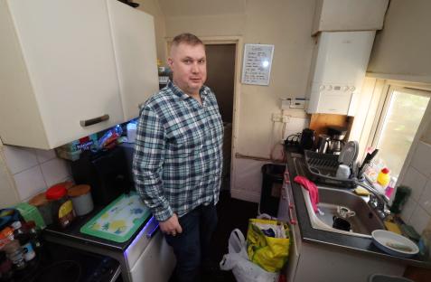 Man in his kitchen, overrun with rats.