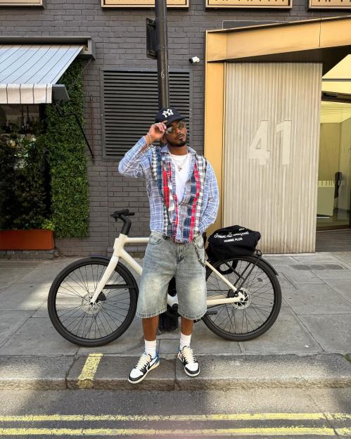 Person standing next to a bicycle on a city street.