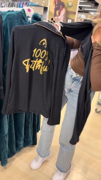 A black shirt with "100% Faithful" written in gold on the back.