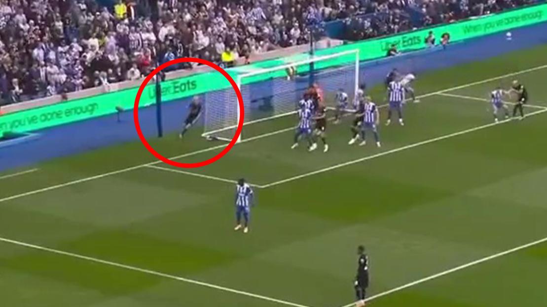 A soccer player highlighted in a red circle falling backwards into a goal net.