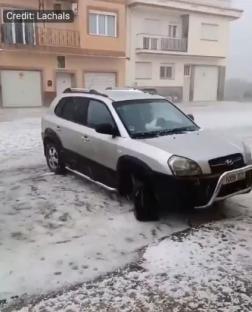 Car covered in hail during a storm in Valencia, Spain.