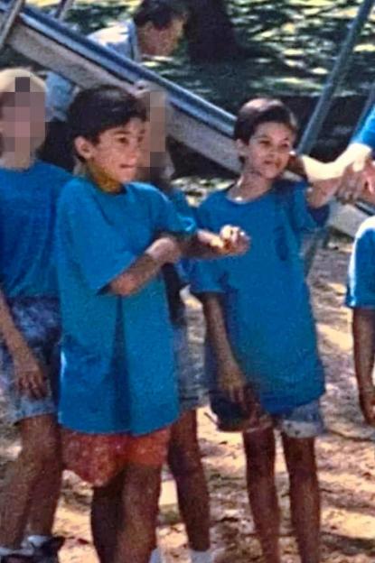 Photo of two young boys in blue shirts at a playground.