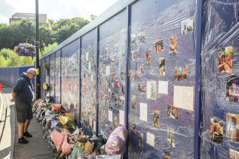Memorial with photos and flowers for a 21-year-old woman killed in a hit-and-run.