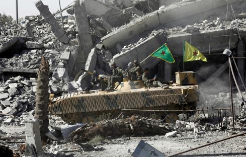 Syrian Democratic Forces fighters on an armored vehicle in Raqqa, Syria.