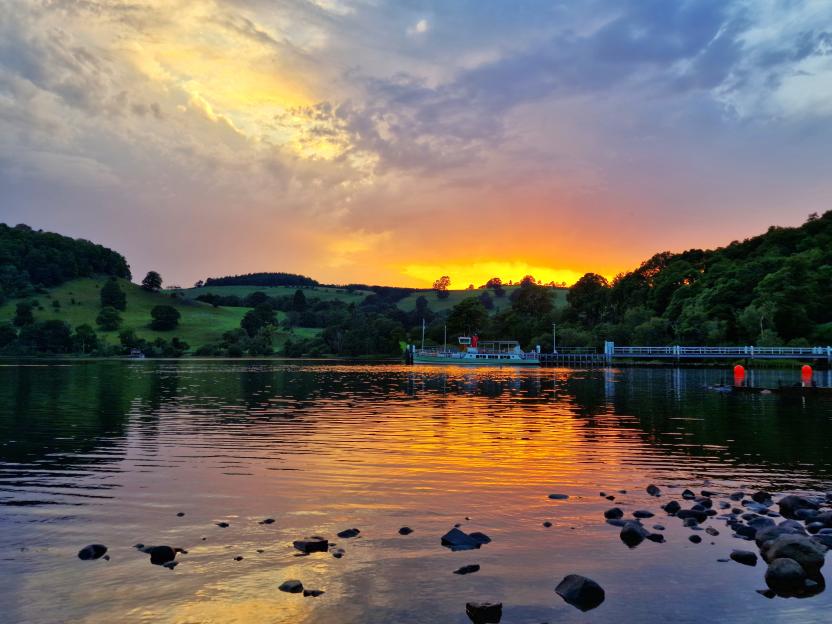 Sunset over Ullswater with a boat at Pooley Bridge.
