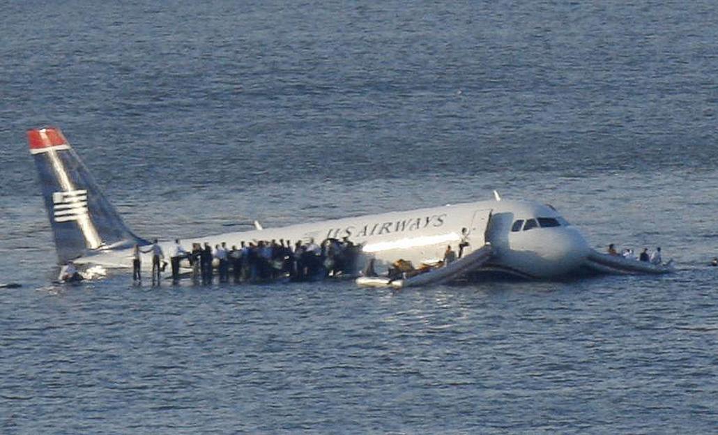 US Airways plane floating in the Hudson River with passengers on the wings.