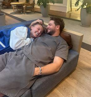 Couple cuddling on a couch.