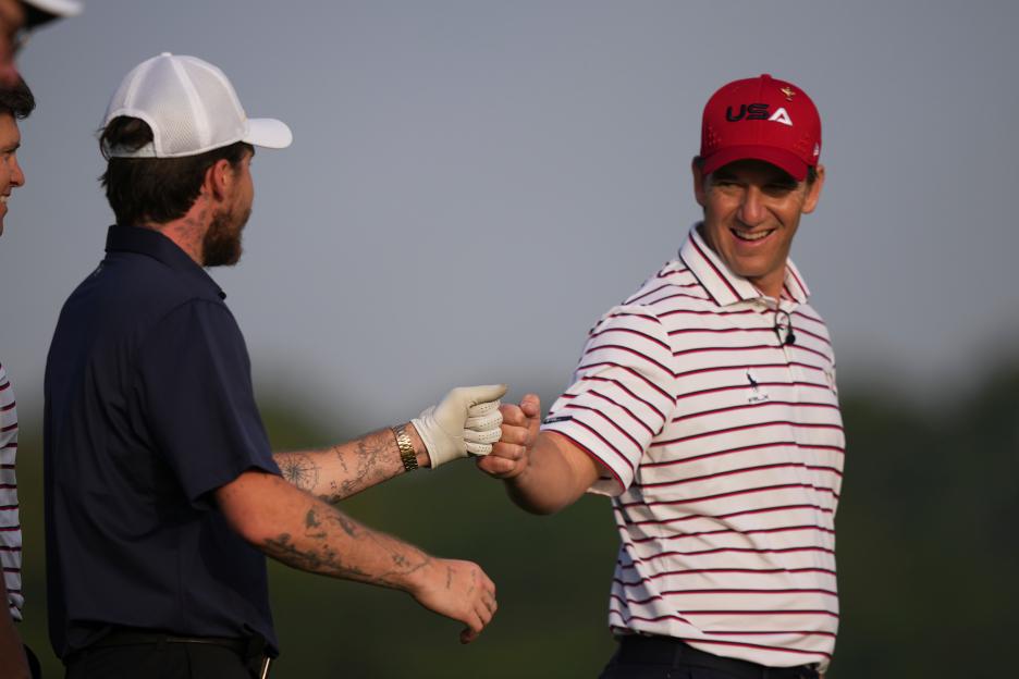 Eli Manning and Brooklyn Peltz Beckham exchange a fist bump on a golf course.