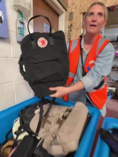 Person holding up a Fjällräven Kånken backpack found at a charity shop.
