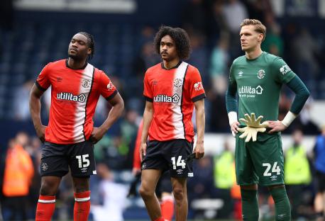 Three Luton Town football players looking dejected after relegation.