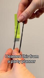 Hands holding two black hair ties.