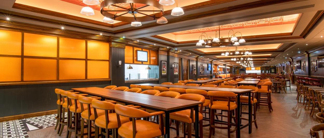 A luxury suite in Old Trafford, The International, with multiple rows of tall tables and chairs.
