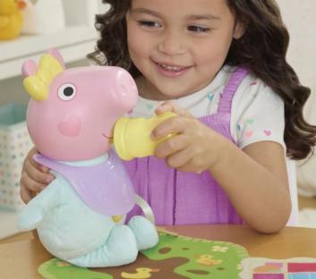 Girl feeding baby Peppa Pig toy.