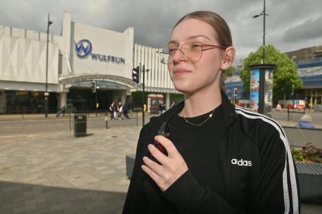 A young woman holding a vape pen.