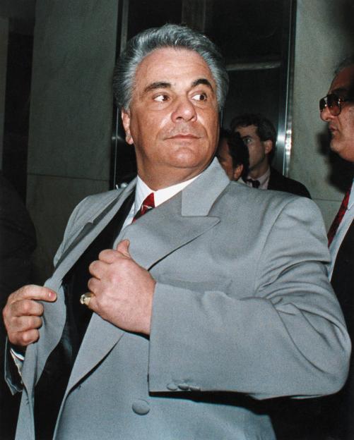 a man in a suit and tie is adjusting his jacket