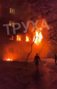 Building engulfed in flames at night.