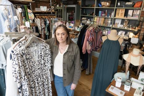A shop owner stands in her clothing boutique.